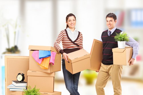 Trained removals staff carrying boxes safely in a residential property